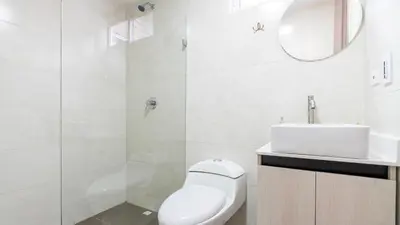 a white bathroom with a toilet and a sink at Apartamento 2BR Parqueadero y Piscina 202 in Medellín