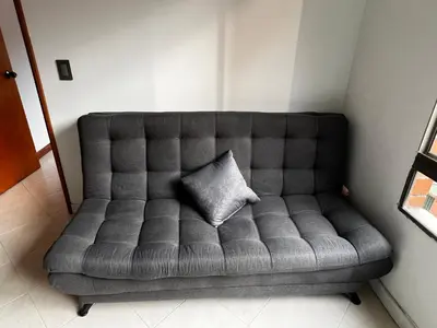 a couch with a pillow on it in a room at Apartaloft in Sabaneta