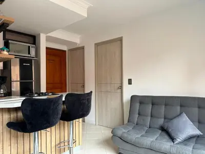 a living room with a couch and a kitchen at Apartaloft in Sabaneta