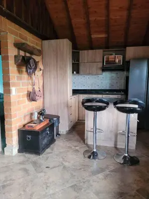 a kitchen with two bar stools and a sink at Pedacito de cielo in San Antonio de Prado