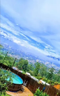 a swimming pool on the side of a house with a view at Pedacito de cielo in San Antonio de Prado