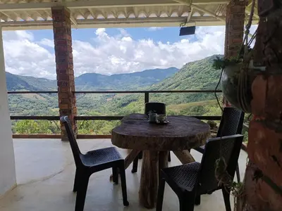 a table and chairs on a balcony with a view at Bosque Místico in San Carlos