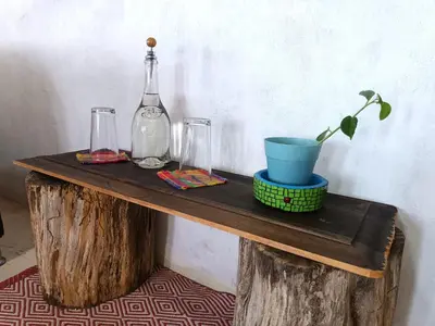 a wooden table with a bottle and a plant on it at Bosque Místico in San Carlos