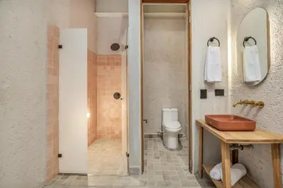 a bathroom with a sink and a toilet at Botánica Casa Hotel Manila by HOUSY in Medellín