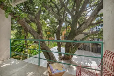 a balcony with a tree in front of a building at Botánica Casa Hotel Manila by HOUSY in Medellín