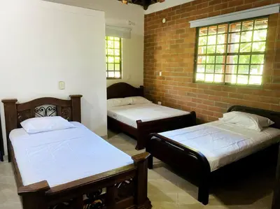 a room with two beds and a brick wall at Finca con Piscina Privada in San Jerónimo