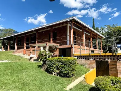 a large wooden house with a large deck at Finca con Piscina Privada in San Jerónimo