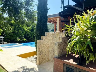 a house with a stone wall and a swimming pool at Finca con Piscina Privada in San Jerónimo
