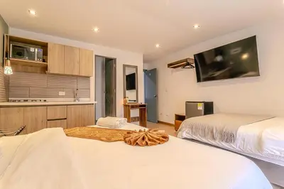 a bedroom with two beds and a tv on the wall at Loft Recuerdos de mi tierra in Medellín