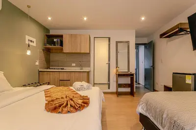 a hotel room with two beds and a kitchen at Loft Recuerdos de mi tierra in Medellín