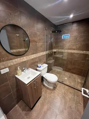 a bathroom with a toilet and a sink and a mirror at Loft Recuerdos de mi tierra in Medellín