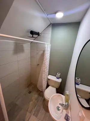 a bathroom with a toilet and a sink and a mirror at Loft Recuerdos de mi tierra in Medellín