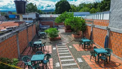 an outdoor patio with tables and chairs on a brick wall at Casa de Veraneo in Mariquita