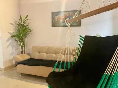 a hammock in a living room with a couch at explora la magia de laureles in Medellín