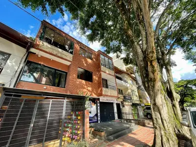 a brick building with a tree in front of it at explora la magia de laureles in Medellín