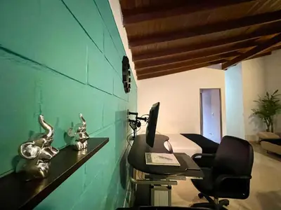 a desk with a computer and a chair in a room at explora la magia de laureles in Medellín