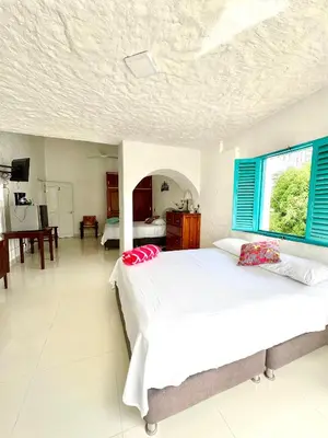 a bedroom with two beds with blue shutters at Plaza Blanca in Doradal