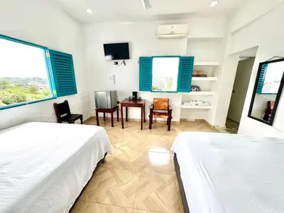 a bedroom with two beds and a table and chairs at Plaza Blanca in Doradal