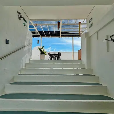 a set of stairs with a table and a chair at Plaza Blanca in Doradal