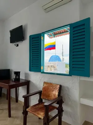 a room with a window and a chair and a table at Plaza Blanca in Doradal