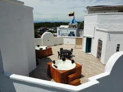 a balcony with tables and chairs on top of a building at Plaza Blanca in Doradal
