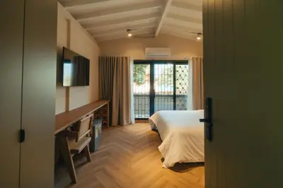 a bedroom with a bed and a desk and a window at Hotel Boutique Roomzz Laureles in Medellín