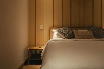 a bedroom with a bed with pillows and a table at Hotel Boutique Roomzz Laureles in Medellín