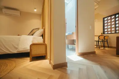 a bedroom with a bed and a living room at Hotel Boutique Roomzz Laureles in Medellín