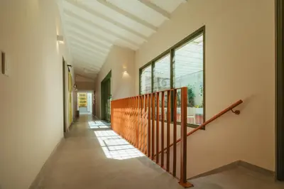 a hallway of a house with a staircase and windows at Hotel Boutique Roomzz Laureles in Medellín