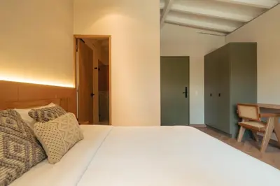 a bedroom with a white bed and a table at Hotel Boutique Roomzz Laureles in Medellín
