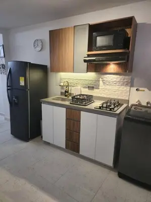 a kitchen with a refrigerator and a stove and a microwave at Acogedor apartaloft El Poblado in Medellín