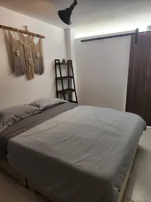 a bedroom with a bed and a ladder and a window at Acogedor apartaloft El Poblado in Medellín