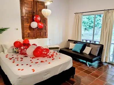 a bedroom with a bed with red and white balloons on it at Finca Hotel La Estancia Santa Fe in Santa Fe de Antioquia