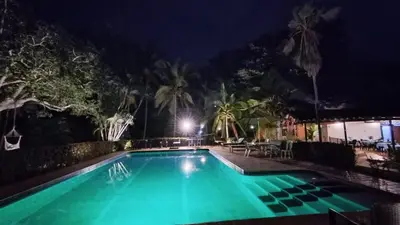 a swimming pool lit up at night at Finca Hotel La Estancia Santa Fe in Santa Fe de Antioquia