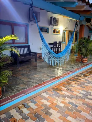 a porch with a hammock in a house at Hotel Bosque Blue in San Jerónimo