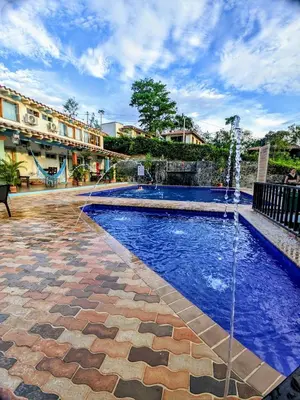 a swimming pool with a fountain in a courtyard at Hotel Bosque Blue in San Jerónimo