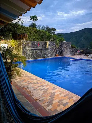 a large blue swimming pool with a waterfall at Hotel Bosque Blue in San Jerónimo
