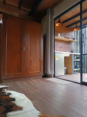 a kitchen with a wooden floor and a refrigerator at Cabaña Momotus II in Concepción
