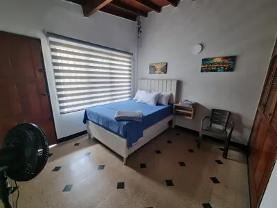 a bedroom with a bed and a desk and a window at Amplia y Cómoda casa en la 70 in Medellín