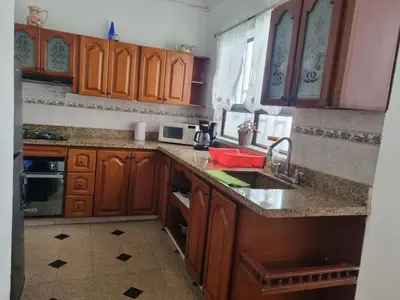a kitchen with wooden cabinets and a counter top at Amplia y Cómoda casa en la 70 in Medellín