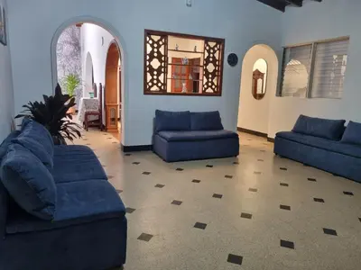 a living room with two blue couches and a mirror at Amplia y Cómoda casa en la 70 in Medellín