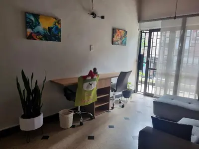 an office with a desk and chairs in a room at Amplia y Cómoda casa en la 70 in Medellín