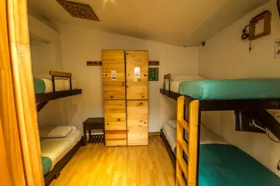 a room with three bunk beds and a closet at Hostal de la 57 in Manizales