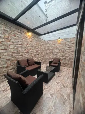 a room with couches and chairs in a brick wall at Espectacular Casa Familiar in Belén