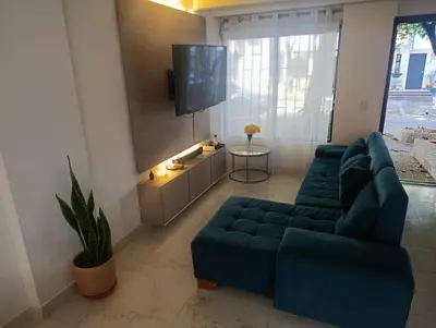 a living room with a blue couch and a tv at Espectacular Casa Familiar in Belén