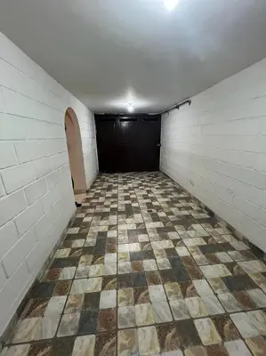 an empty room with a tiled floor and a black door at Espectacular Casa Familiar in Belén