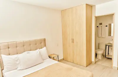 a bedroom with a large bed and a bathroom at Apartahotel Castellana in América