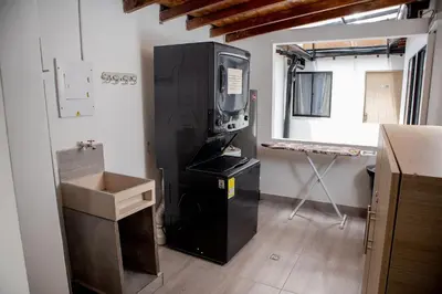 a kitchen with a large black refrigerator in a room at Apartahotel Castellana in América