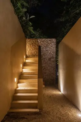 a stairway leading up to a building at night at Arde La Selva in Santa Fe de Antioquia