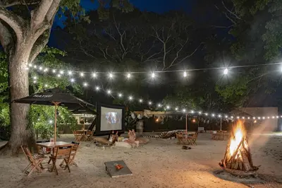 a fire pit with chairs and an umbrella and lights at Arde La Selva in Santa Fe de Antioquia